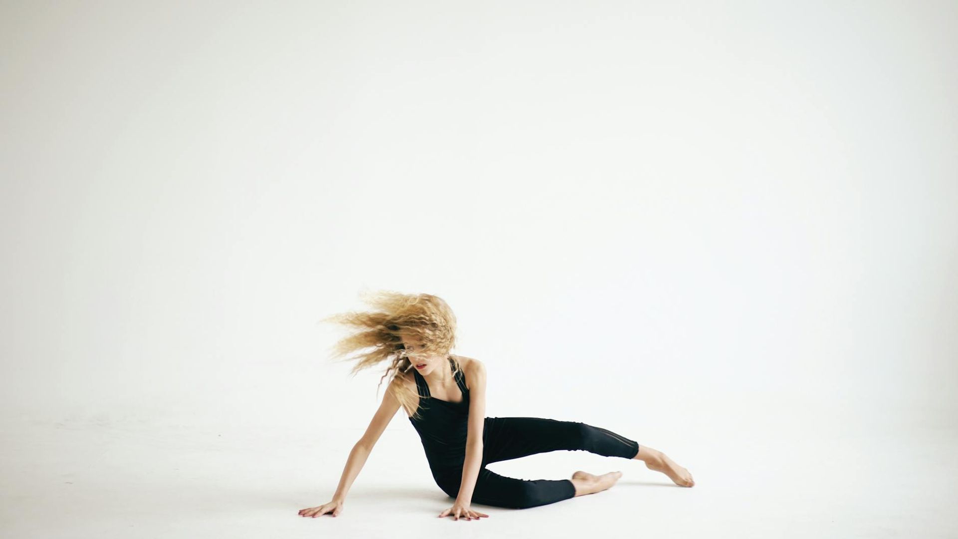 Person performing energetic movement in a bright modern studio space